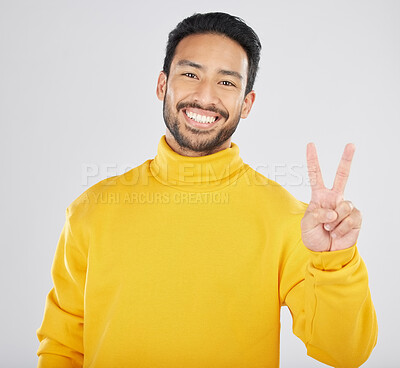 Buy stock photo Young man, peace sign and studio portrait with smile, vote and show icon for opinion by white background. Indian fashion model, guy or student with hand, gesture or emoji for voice, freedom or review