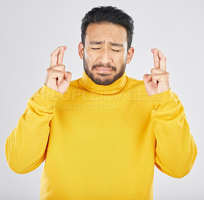 Buy stock photo Nervous, face and fingers crossed by asian man in studio with anxiety for news, feedback or review on grey background. Hand, emoji and Japanese guy with anxious for results, competition or giveaway