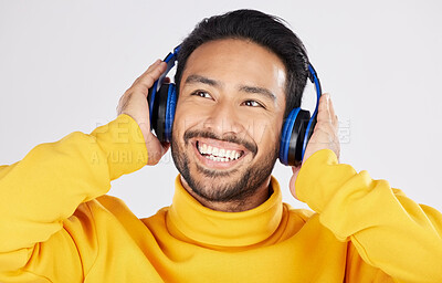 Buy stock photo Model man, headphones and smile in studio, thinking and ideas with streaming subscription by white background. Young student guy, audio and happy with sound tech, music and listening to online radio