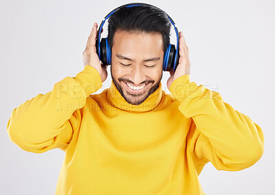 Buy stock photo Man, headphones and listening with smile, studio and hearing with streaming subscription by white background. Young Mexican guy, student or fashion model with audio, music and sound with online radio