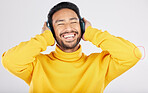 Man, headphones and excited for listening in studio, smile or hearing with streaming subscription by white background. Indian guy, student or fashion model with audio, music or happy for online radio