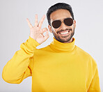 Fashion, happy and man with okay sign on a white background for approval, agreement and yes. Emoji, sunglasses and face of person smile in studio with perfect, good review and support hand gesture