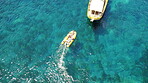 People on boat from above, sailing in Greece and summer sun on ocean holiday, relax in freedom and nature. Yacht vacation, aerial view of travel and tropical cruise on sea adventure to Greek island.