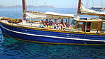 Group of people on boat, sailing in Greece and summer sun on ocean holiday, relax in freedom and nature. Yacht vacation, family travel and tropical cruise on sea adventure to Greek island on blue sky