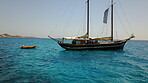 Yacht, sailing in Greece and summer on ocean holiday, relax in freedom and people swimming in blue water. Boat vacation, travel in sun and tropical cruise on sea adventure to with island beach fun.