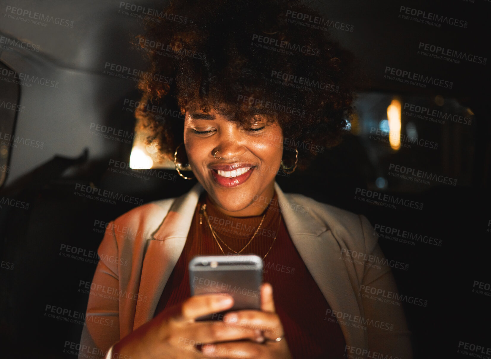 Buy stock photo Black woman, afro and phone at night in taxi, travel or communication in social media or networking. Happy African female person smile in online chatting or late evening on mobile smartphone in car