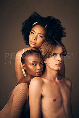 Buy stock photo Makeup, glow and portrait of models in studio with creative, cosmetic and facial art for beauty. Queer, diversity and gen z man and women with face inclusion or skincare isolated by brown background.