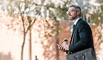 Mature business man, city and building, glasses and cellphone with coffee and bag in street on bokeh background. Entrepreneur, professional person and manager standing and wait for traffic outside  