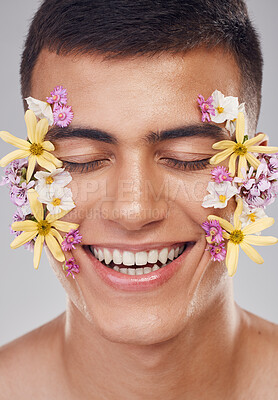 Buy stock photo Relax, face or happy man with flowers for beauty, natural cosmetics or wellness in studio on white background. Nature aesthetic, smile or model laughing at eco friendly skincare or spring floral art