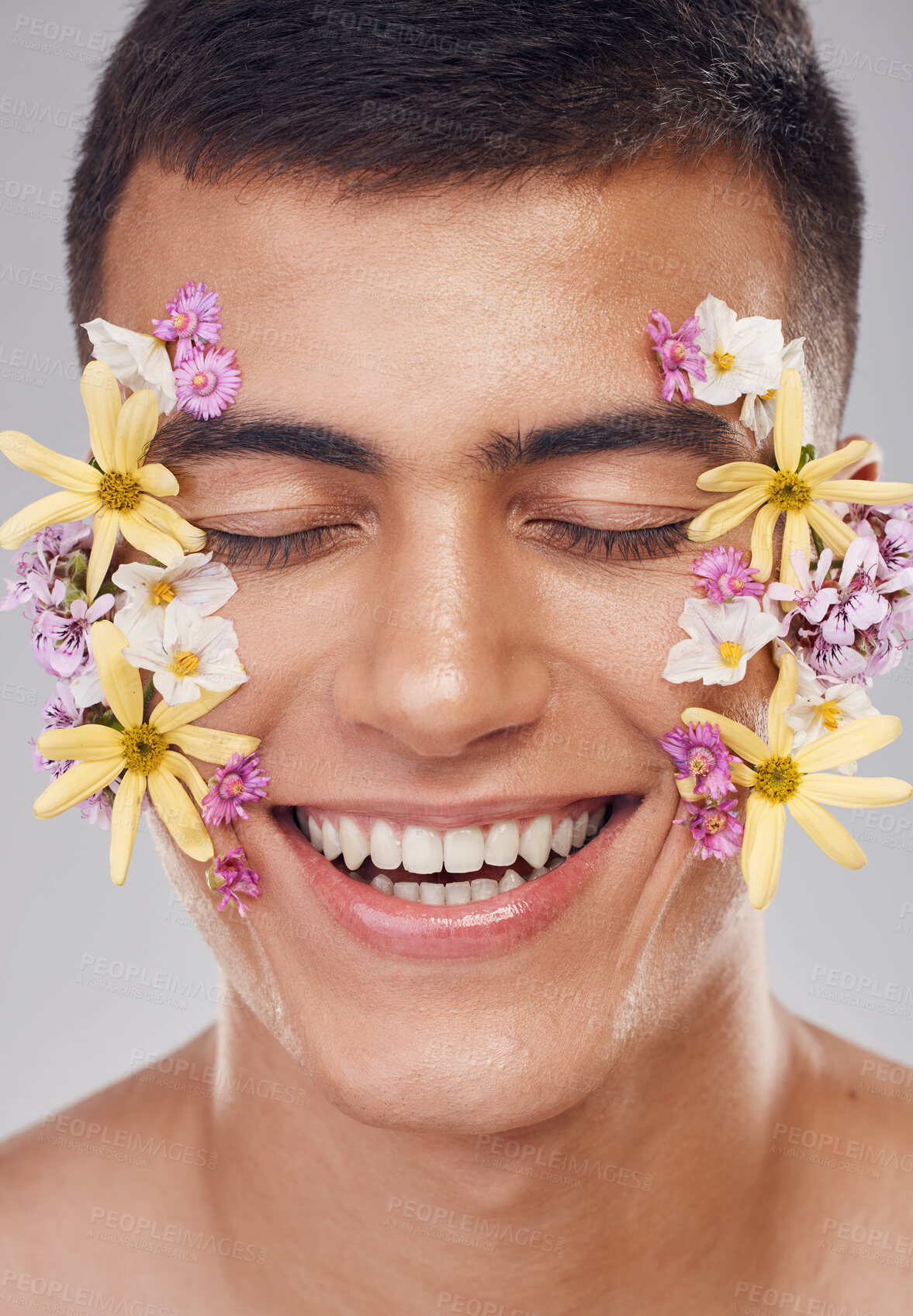 Buy stock photo Relax, face or happy man with flowers for beauty, natural cosmetics or wellness in studio on white background. Nature aesthetic, smile or model laughing at eco friendly skincare or spring floral art