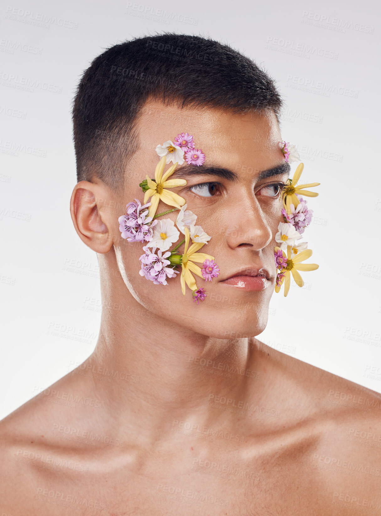 Buy stock photo Thinking, creative and a man with flowers on a studio background for ecology or nature aesthetic. Floral, serious and a male model with plants for facial cosmetics, skincare or an idea on a backdrop