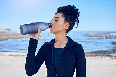 Buy stock photo Woman, fitness and drinking water by ocean for training, exercise and workout nutrition, health or wellness outdoor. Tired runner or african person with liquid bottle for energy, sports and cardio
