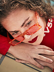 Face, fashion and sunglasses with a woman lifeguard on duty closeup in a swimming pool for safety. Summer, thinking and poolside with a young professional swimmer looking bored waiting for a rescue