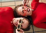 Women portrait, sunglasses and happy with fashion at a pool with gen z and style of girl friends with streetwear. Red clothing, cool and trendy glasses with young people together on a tile floor