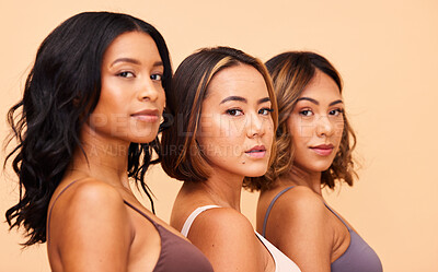 Buy stock photo Diversity, beauty and portrait of women in row with self love, solidarity and pride in studio together. Face, group of people on beige background with underwear, skincare and cosmetics for hair care.