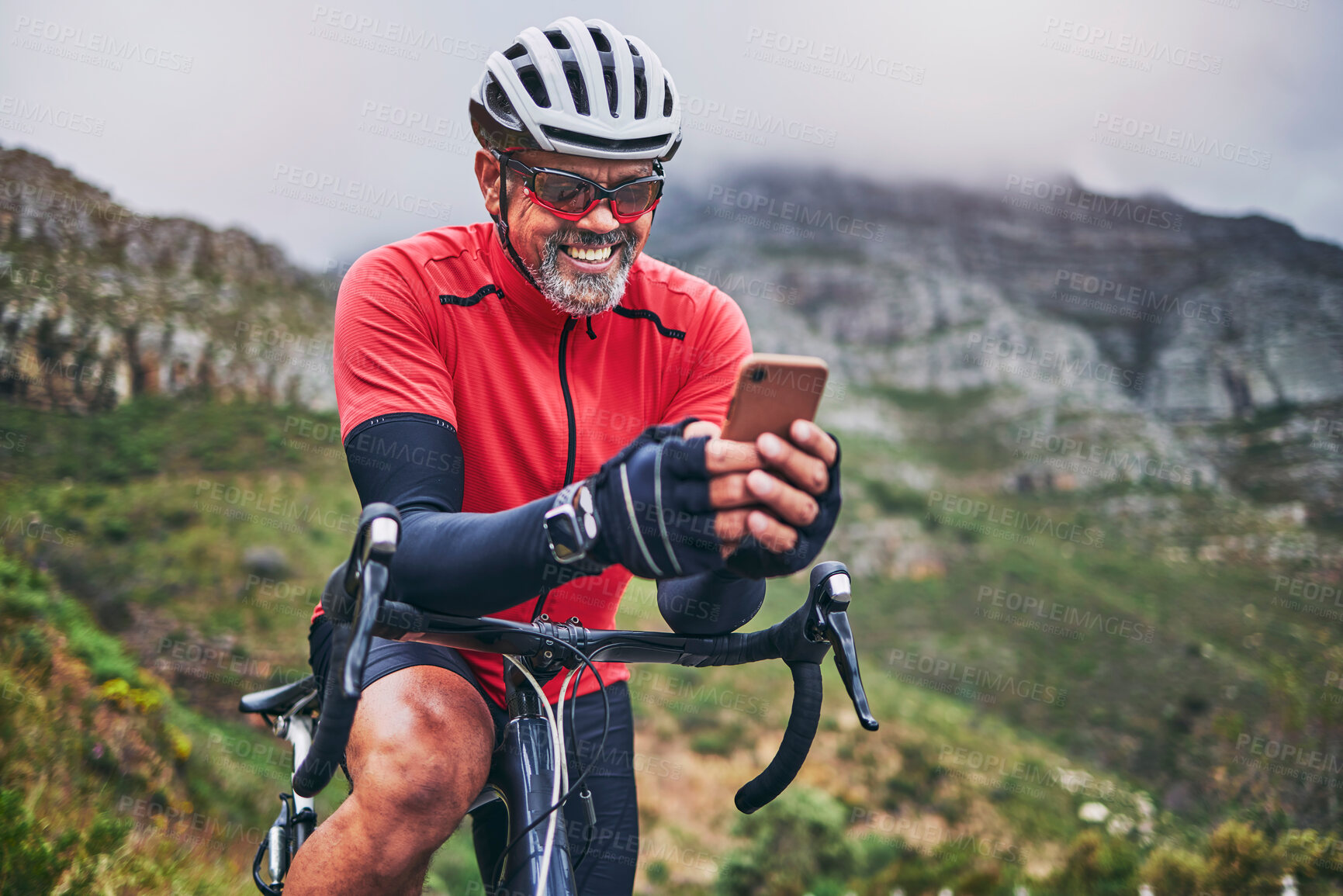 Buy stock photo Happy man, cyclist and phone on mountain bicycle in communication, social media or networking in nature. Male person or athlete smile on mobile smartphone app in sports workout, fitness or cycling
