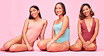 Diversity, underwear and portrait of happy women in studio, sitting together with smile and body positivity. Beauty, summer fashion and swimwear models with self love, equality and pink background.