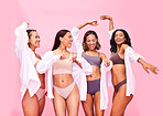 Dancing, happy and women friends in underwear in studio on a pink background for beauty or skincare. Lingerie, health and fun with female model group posing for diversity, body positive or inclusion

