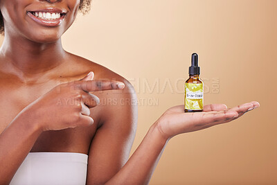 Buy stock photo Hand, pointing and a woman with a product for skincare in her palm on a brown background in studio. Beauty, serum or treatment with a happy model showing a bottle for promotion or advertising