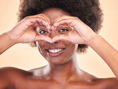 Buy stock photo Smile, portrait and a black woman with heart hands on a studio background for love or support. Happy, emoji and face of African girl or model with a sign or gesture for care or kindness on a backdrop