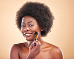 Portrait, beauty and a black woman with a makeup brush for blush to apply cosmetics to her face. Smile, aesthetic and afro with a happy young model using a product on her skin to enhance appearance