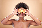 Orange fruits, skincare and woman on studio background for natural cosmetics, healthy benefits and nutrition. Happy african beauty model cover eyes with citrus for vitamin c, detox or eco dermatology