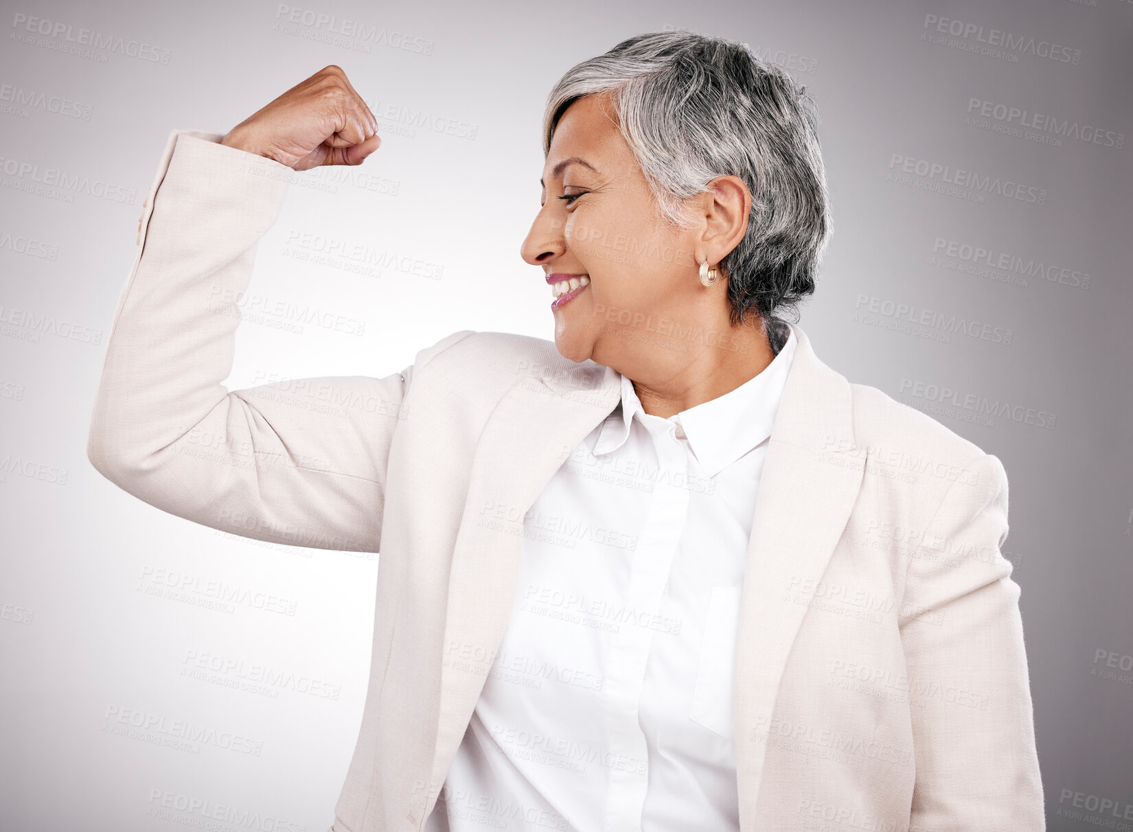 Buy stock photo Strong, smile and mature businesswoman in a studio with strength, feminism or confidence gesture. Happy, empowerment and female model from Mexico flexing her arm muscles for emoji by gray background.