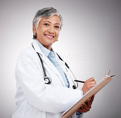 Buy stock photo Happy woman, portrait and doctor with clipboard in studio, planning notes or healthcare information. Mature medical worker writing report of insurance checklist, medicine or script on gray background