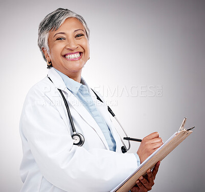 Buy stock photo Woman, portrait and doctor writing on clipboard in studio for notes, healthcare administration or info. Happy mature surgeon with report of insurance checklist, documents or script on gray background