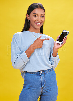 Buy stock photo Woman, portrait and phone screen in presentation, advertising space and e learning news or opportunity in studio. Young person or student pointing to mobile app or contact mockup on yellow background