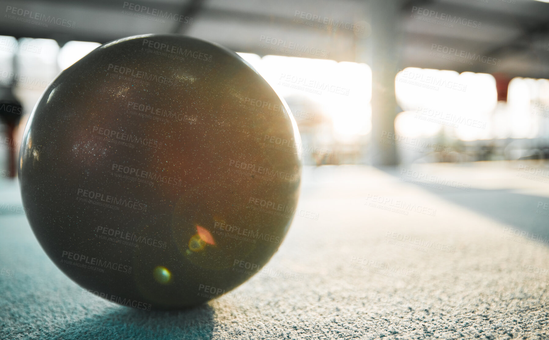 Buy stock photo Gymnastics ball on floor for sports, fitness and lens flare with mockup for exercise, performance or rhythmic dance. Light, ground and aerobics equipment in gym, arena or workout space with sunshine.