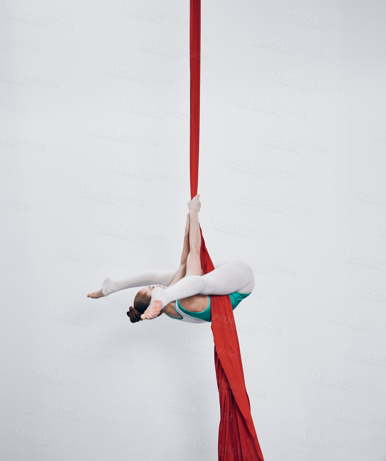 Buy stock photo Gymnastics, acrobat and aerial silk with a woman in air for performance, sports and balance. Young athlete person or gymnast hanging on red fabric and white background with space, art and creativity