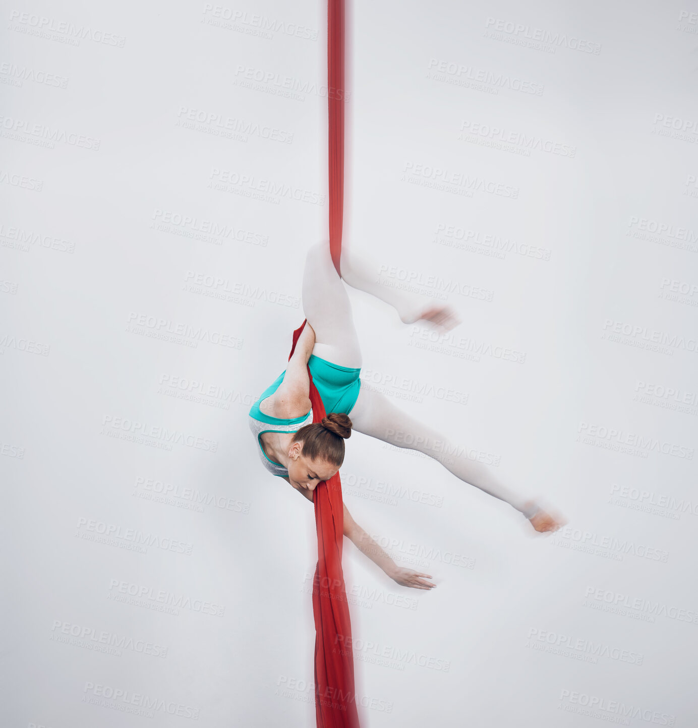 Buy stock photo Gymnastics, acrobat and aerial silk with a sports woman in air for performance and balance. Young athlete person or gymnast hanging on red fabric and white background with space, art and creativity