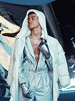 Fashion, future and cyberpunk with a model in a silver outfit for a magazine photo shoot in studio. Art, holographic and sci fi with a young man posing for creative, vaporwave or trendy style