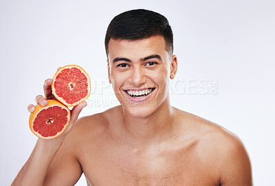 Buy stock photo Skincare, grapefruit and health with portrait of man in studio for beauty, detox and natural cosmetics. Vitamin c, nutrition and spa with person and fruit on white background for self care and glow 