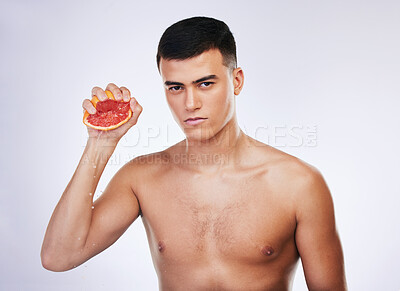 Buy stock photo Skincare, grapefruit and squeeze with portrait of man in studio for beauty, detox and natural cosmetics. Vitamin c, nutrition and spa with person and fruit on white background for self care and glow 