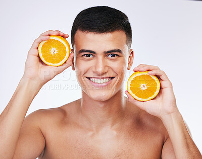 Buy stock photo Beauty, orange and skincare with portrait of man in studio for health, detox and natural cosmetics. Vitamin c, nutrition and summer with face of person and fruit on white background for self care