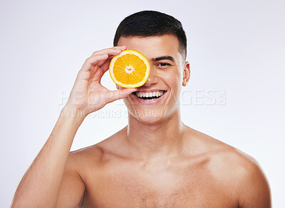 Buy stock photo Beauty, orange and smile with portrait of man in studio for health, skincare and natural cosmetics. Vitamin c, nutrition and summer with face of person and fruit on white background for self care