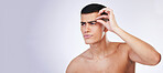 Man, grooming and clean skincare with facial and beauty treatment for skin and wellness in studio. Male model, dermatology and hair removal tool of eyebrows with grey background and mockup space