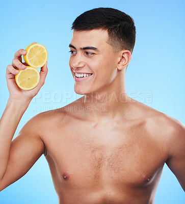 Buy stock photo Beauty, smile and skincare with man and lemon in studio for health, detox and natural cosmetics. Vitamin c, nutrition and summer with person and fruit on blue background for self care, spa and glow 