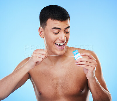 Buy stock photo Dental floss, happy man and teeth cleaning for healthcare, wellness and morning care in studio. Blue background, male model and happy from hygiene with smile from healthy product for tooth protection