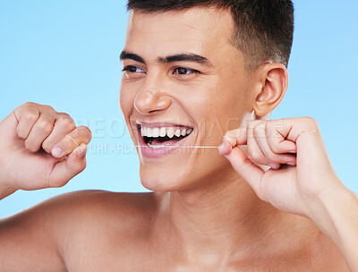 Buy stock photo Happy man, face and dental floss in teeth cleaning, hygiene or grooming against a blue studio background. Male person or model smile with flossing in oral, tooth whitening or gum and mouth care