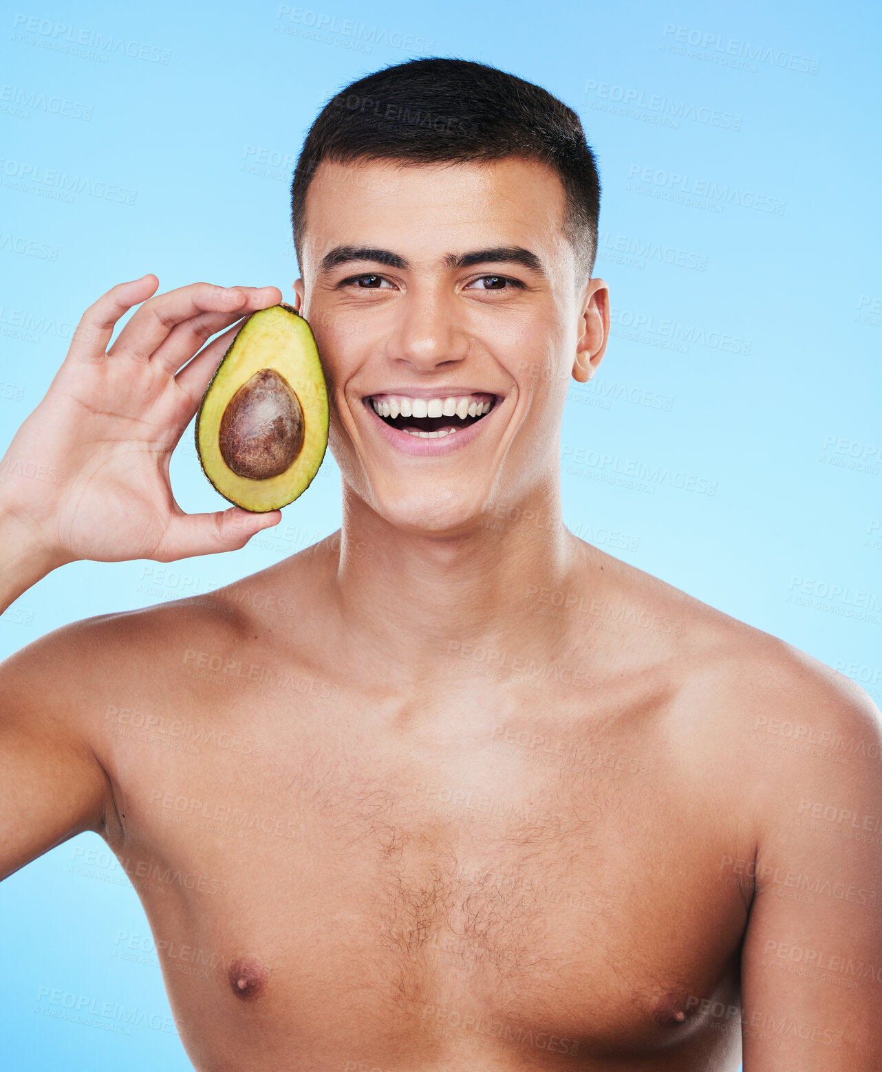 Buy stock photo Avocado, wellness and man smile portrait with skincare and natural facial treatment in studio. Blue background, health food and cosmetics with male model holding fruit for nutrition for face and glow