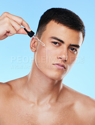 Buy stock photo Man, serum and drop for face in studio with beauty, wellness and facial change by blue background. Young model, oil or hyaluronic acid for glow, shine and cleaning skin with cosmetic transformation