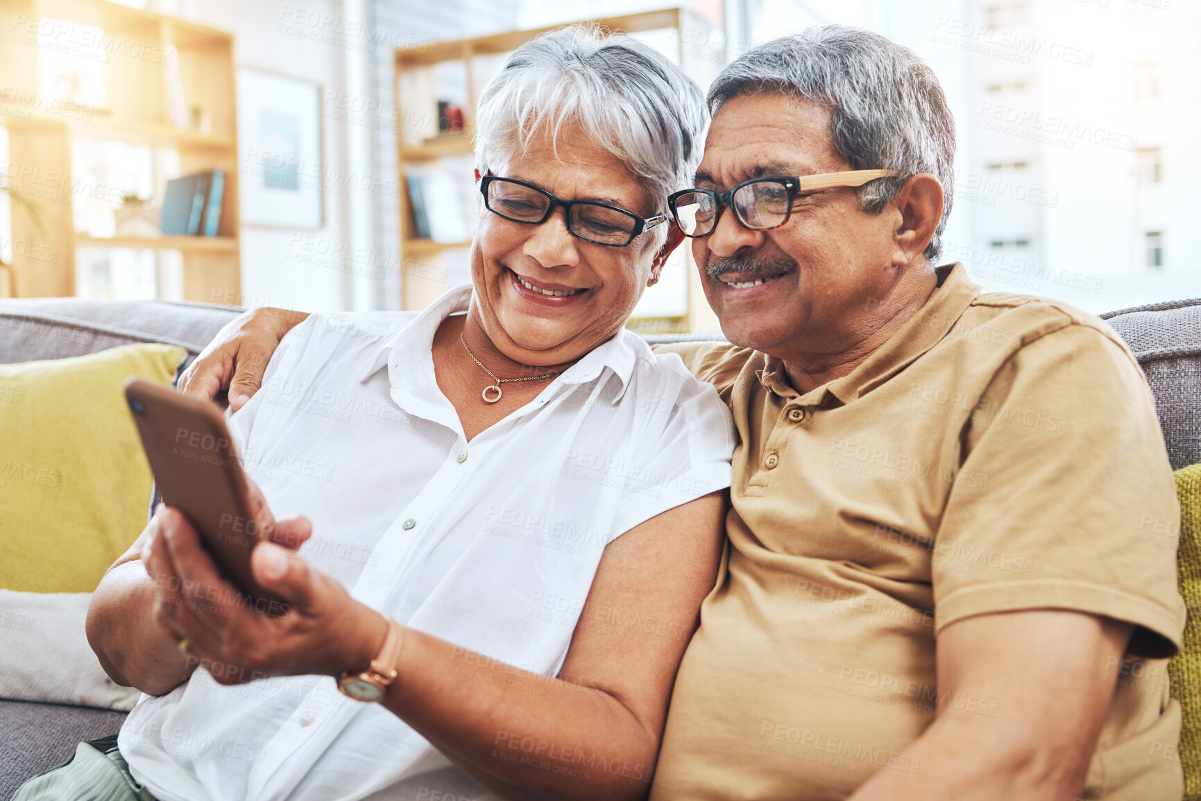 Buy stock photo Senior couple, smile and phone on sofa for social media, reading digital news and notification with glasses. Happy elderly man, woman and scroll on smartphone for app, website and relax in retirement