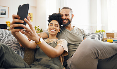 Buy stock photo Interracial couple, selfie and happy on couch, relax at home with social media, streaming and memory with commitment. Smile in picture, post and love, care and trust, people in lounge with romance