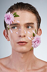 Beauty, skincare and flowers on face of man in studio for spring, natural cosmetics and creative. Glow, self love and floral with model on white background for makeup, spa treatment and wellness