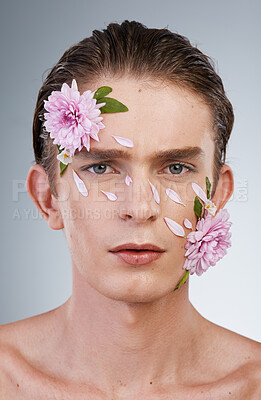 Buy stock photo Head, cosmetics and flowers with portrait of man in studio for beauty, natural skincare and creative. Glow, serious and floral with face of model on white background for makeup, spa and wellness