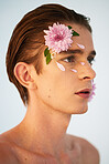 Beauty, petals and flowers on face of man in studio for spring, natural cosmetics and creative. Glow, self love and floral with model on white background for makeup, spa treatment and wellness