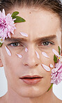 Cosmetics, skincare and flowers with portrait of man in studio for beauty, natural and creative. Glow, self love and spring with face of model on white background for makeup, spa and floral wellness